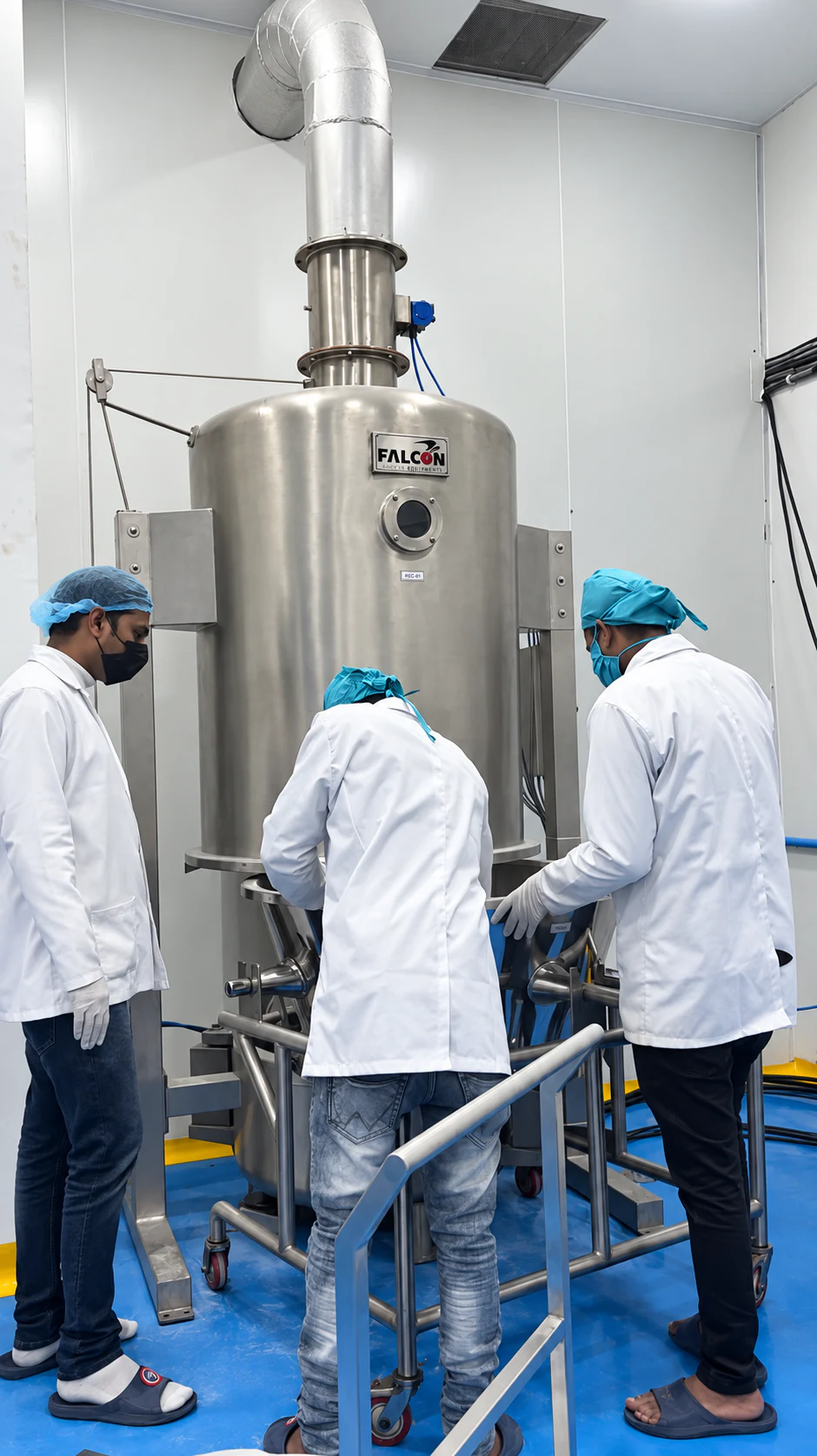 Three Healthy Health team members operating a stainless-steel production machine